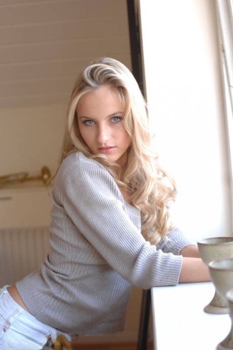Blonde girl with a pretty face reveals her nice tits as she undresses