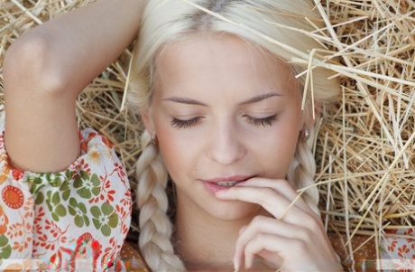 Young cutie Vika D in pigtails pours milk on her bald pussy in the hay stack