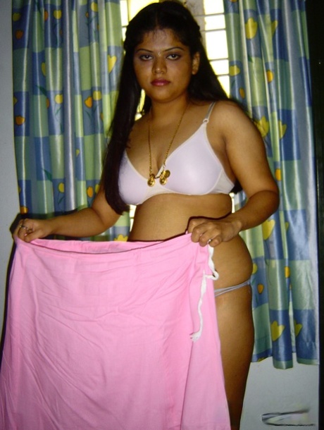 Plump Indian girl Neha gets totally naked on her bed in solo action