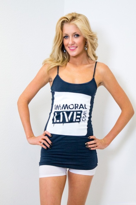 Blonde girl Emily Kae sports a nice smile while stripping to sports socks