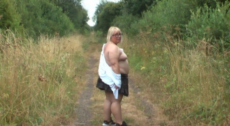 Obese blonde lady Lexie Cummings reveals her pierced pussy in the countryside